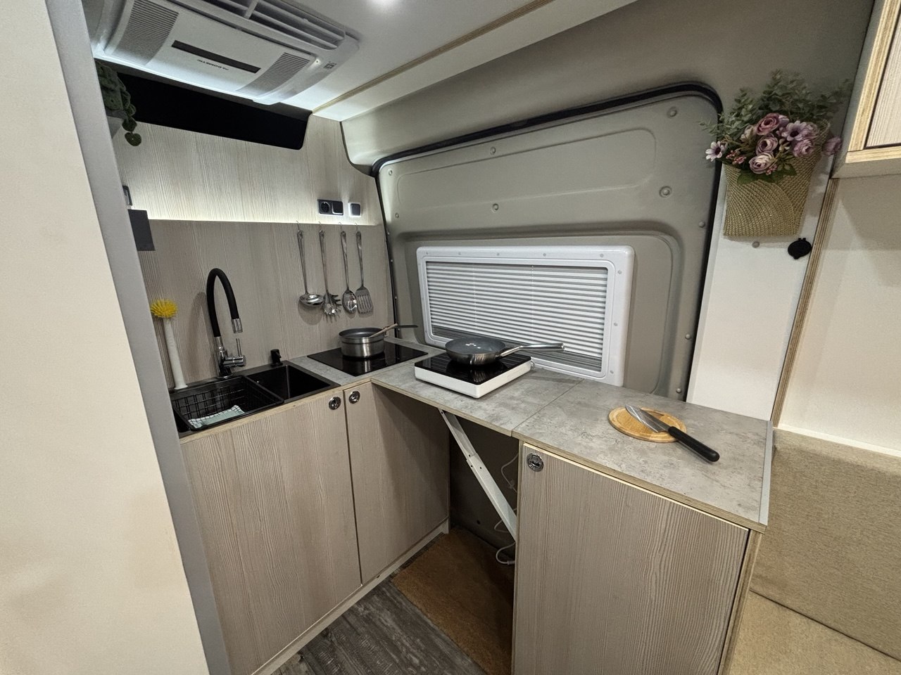 Cocina de La Fitti con placa de inducción, fregadero y encimera de piedra clara